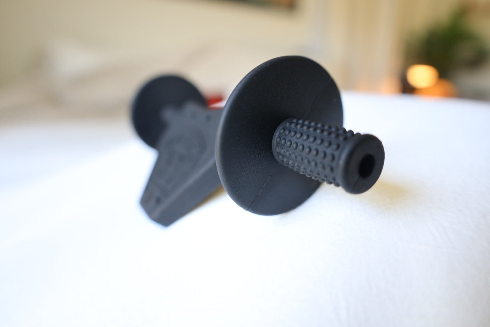 Close-up of the black Moto Since Birth teether's textured silicone grip and hand guard